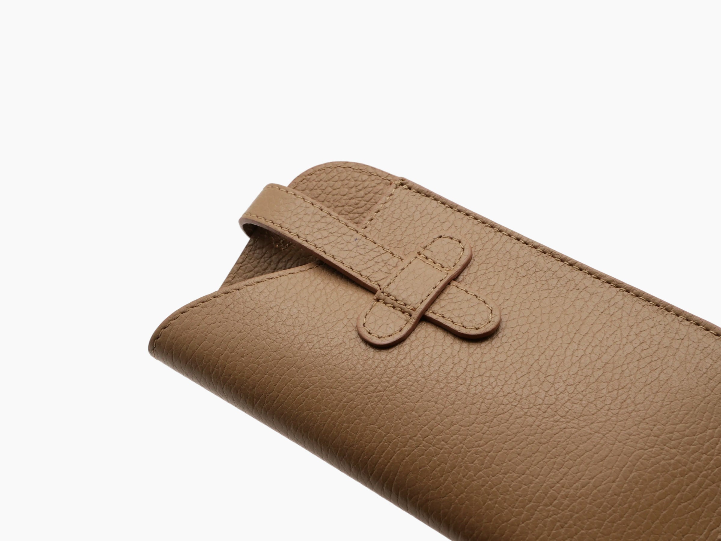 Tan pebbled leather glasses case with a slim strap and silver ring closure