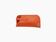 Bright orange buffalo leather glasses case with strap and metal logo accent.