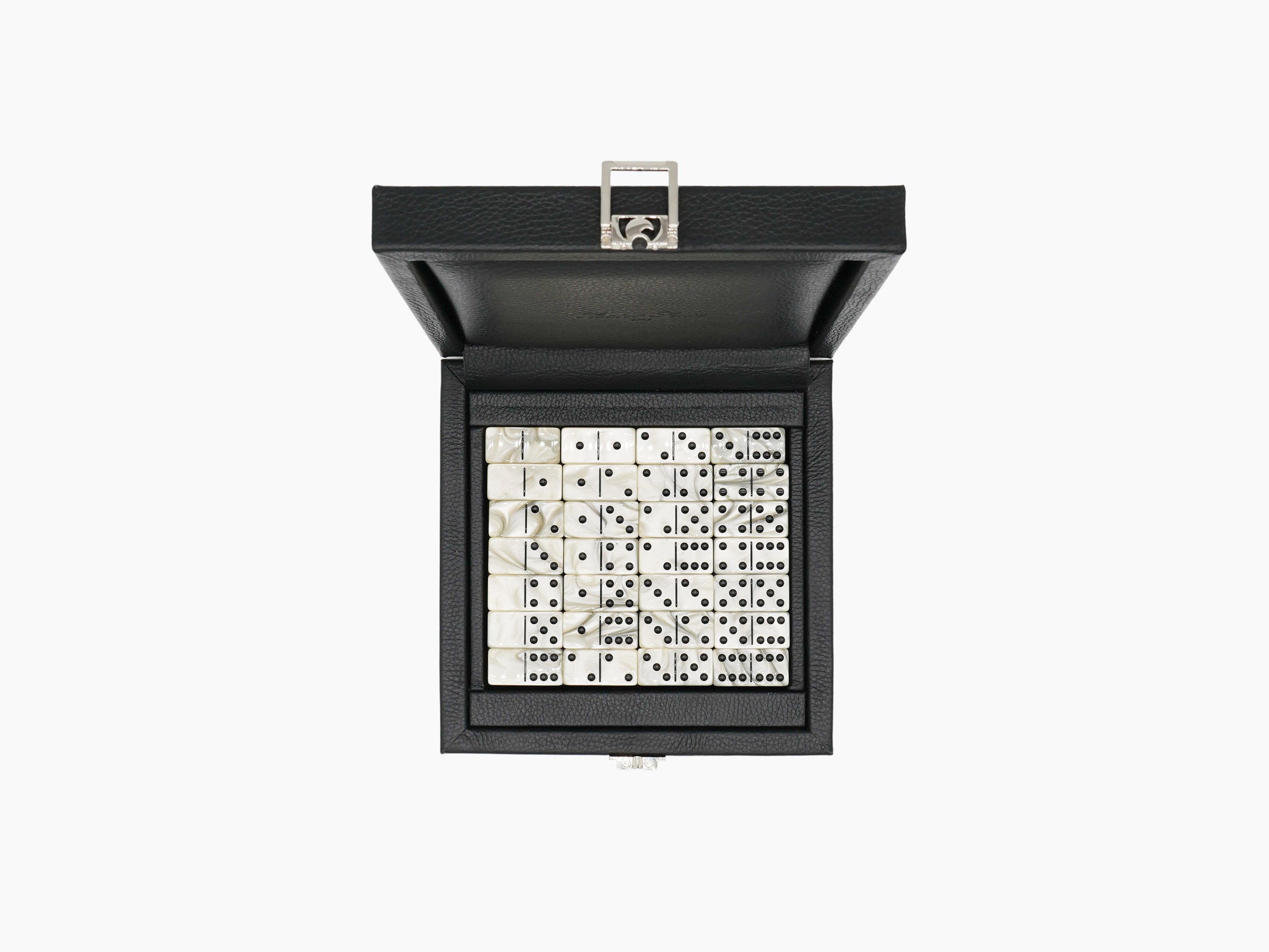 Open black leather domino box with ivory domino tiles laid out in a neat grid