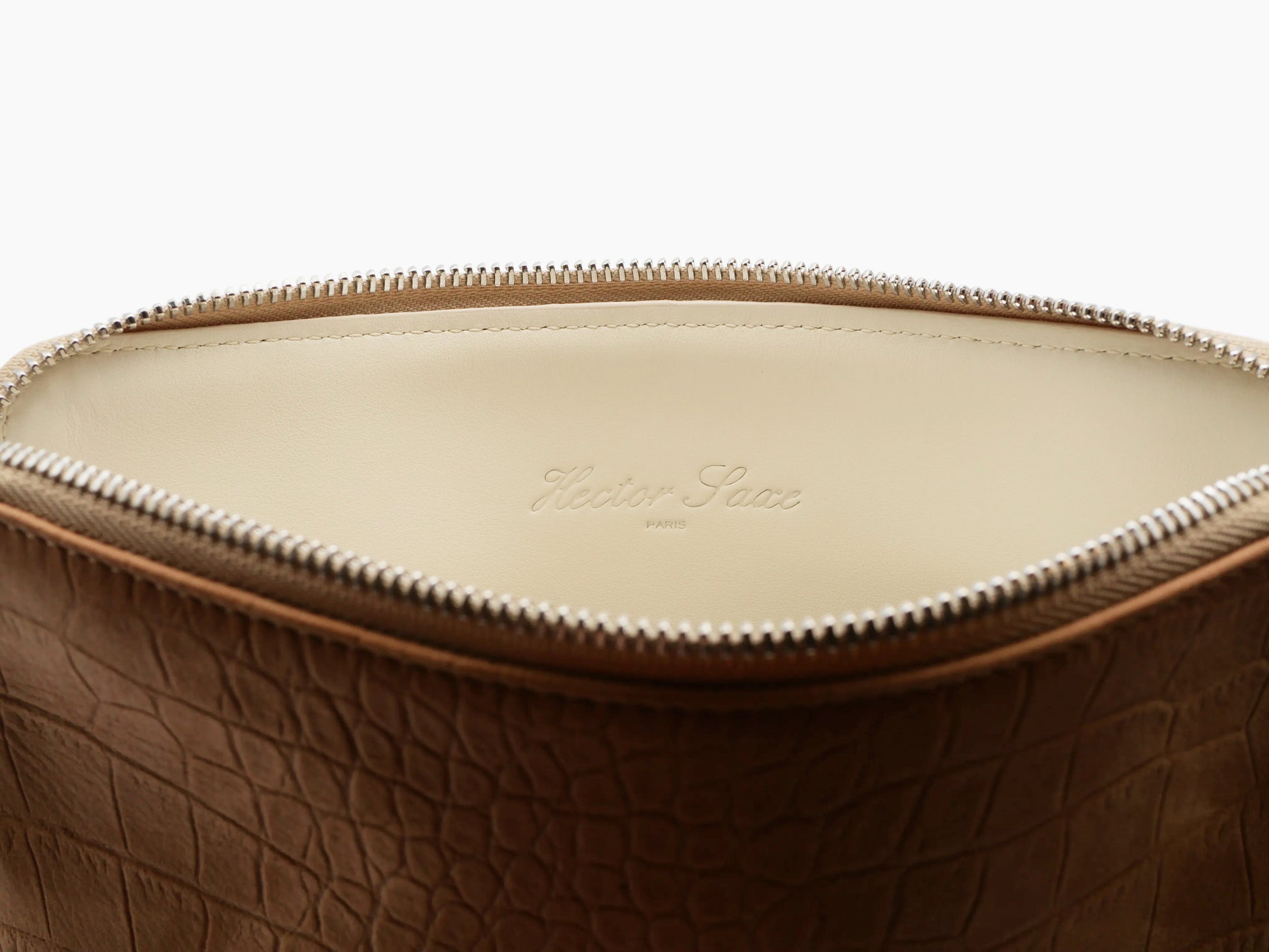 Open top view of crocodile-embossed tan pouch with pale interior and Hector Saxe Paris embossing