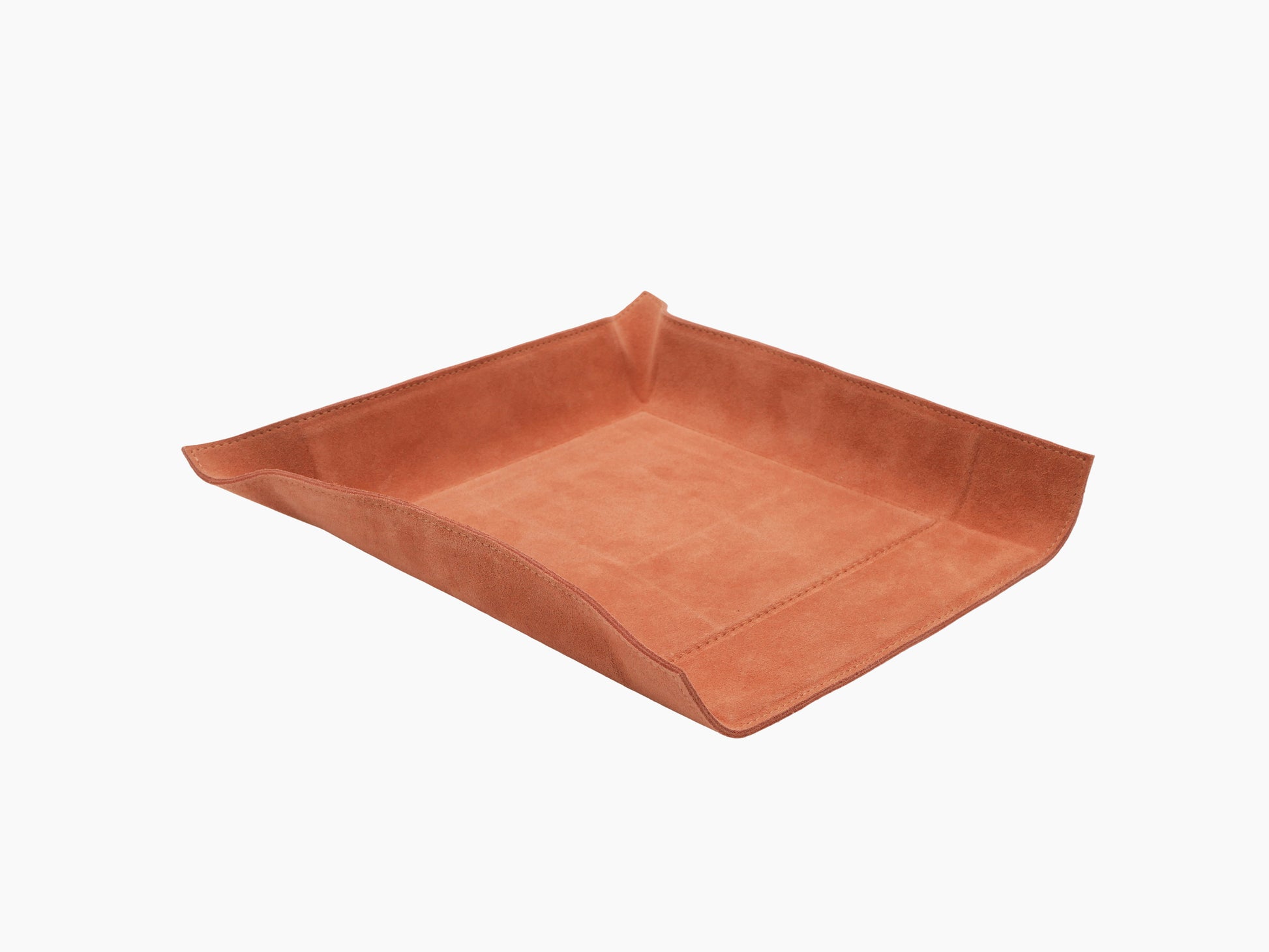 Angled view of square orange leather valet tray with raised sides and suede interior