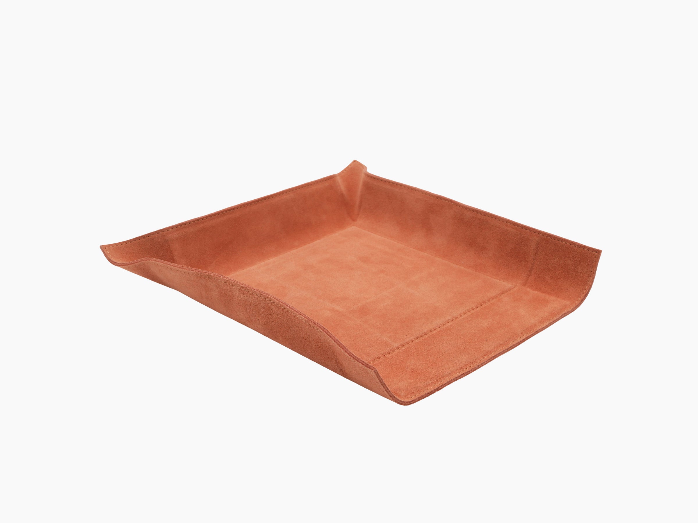 Angled view of square orange leather valet tray with raised sides and suede interior
