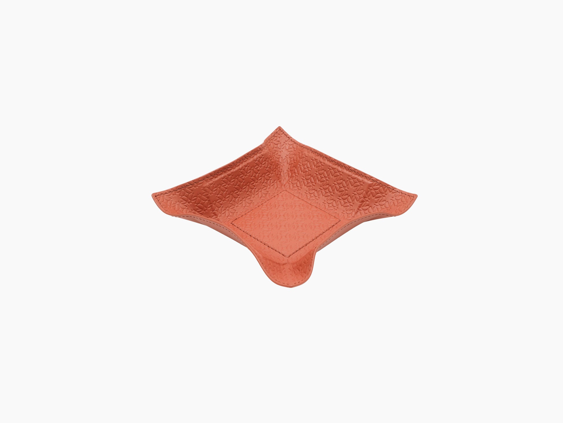 Top view of coral leather valet tray showing embossed monogram and central stitched patch