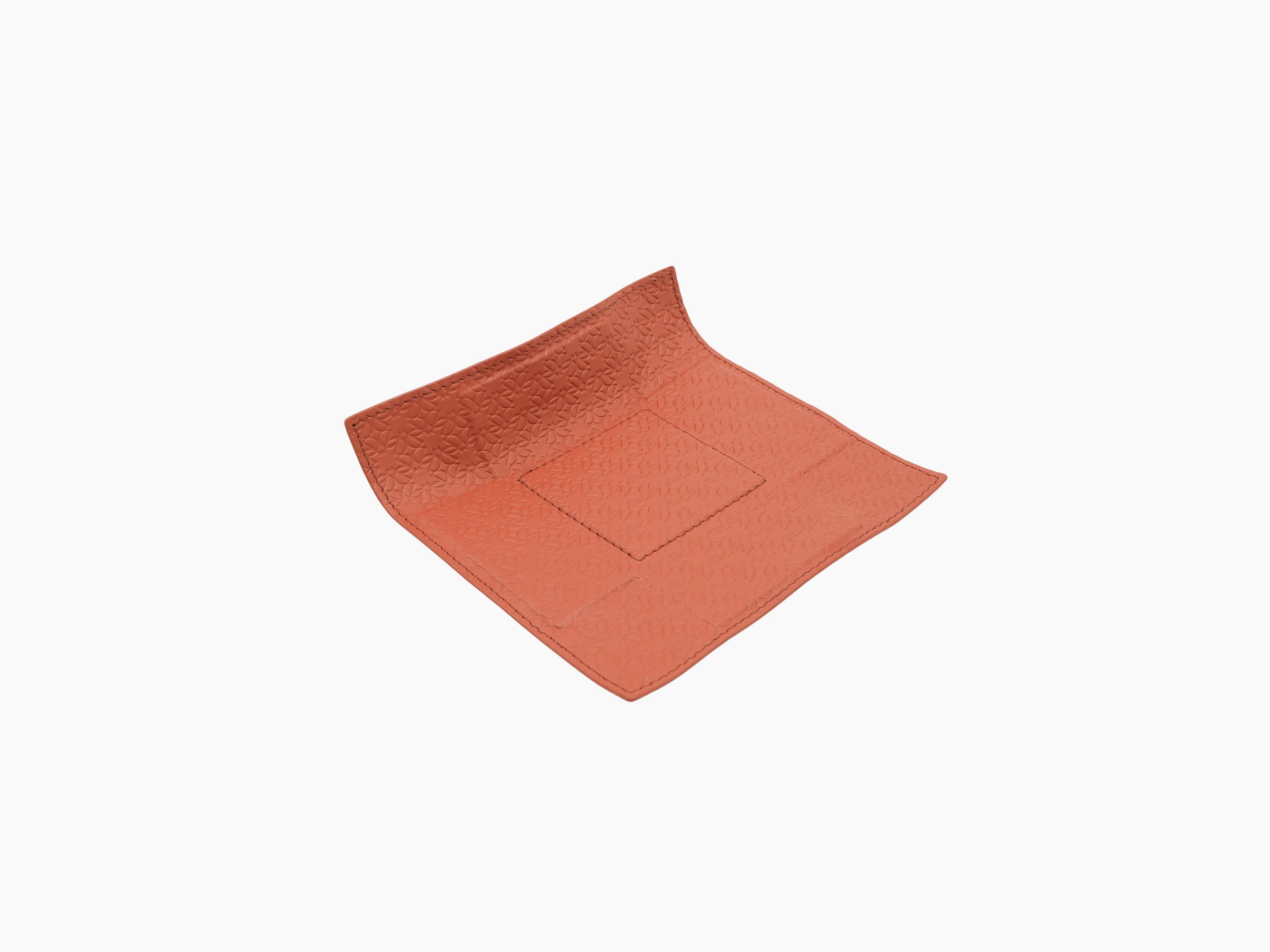 Top view of coral Monogram Valet Tray showing embossed texture and subtle metal frame detail