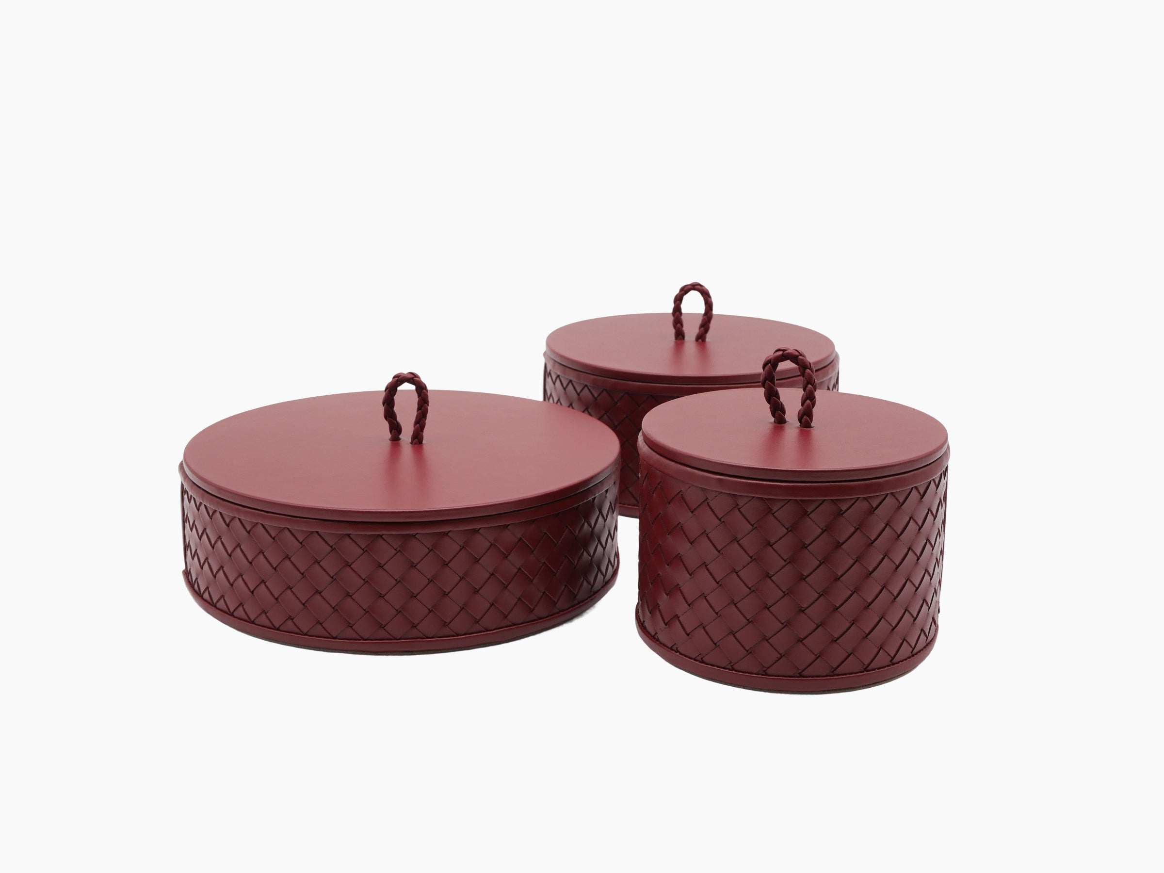 Three burgundy Jana handwoven round leather boxes with quilted diamond pattern and looped handles on the lids
