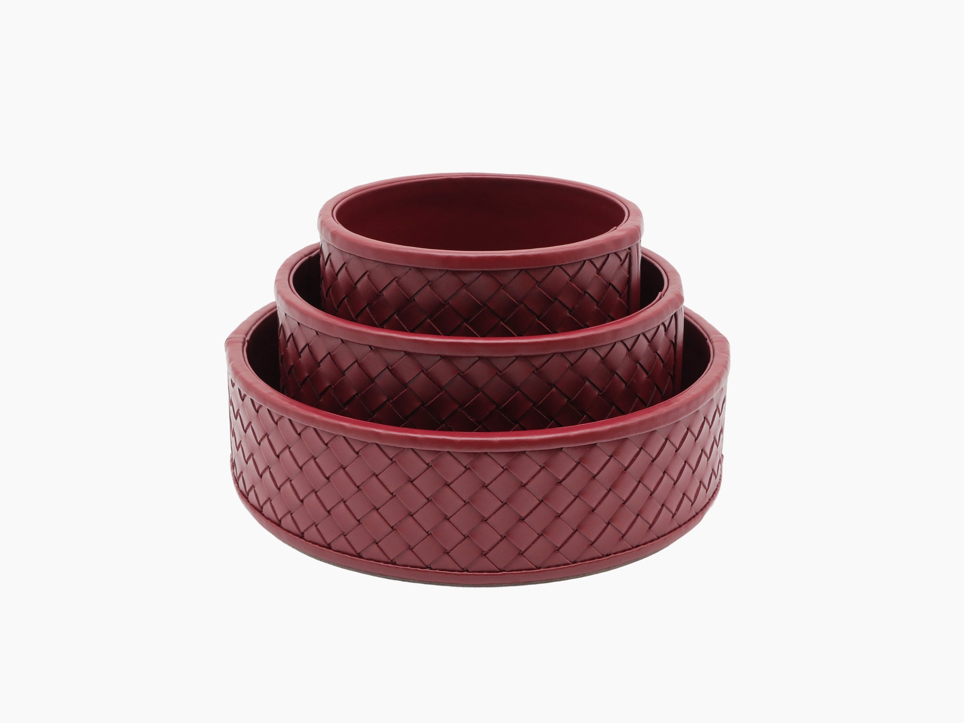 Stacked trio of burgundy Jana handwoven round leather boxes with quilted weave and looped lid handles