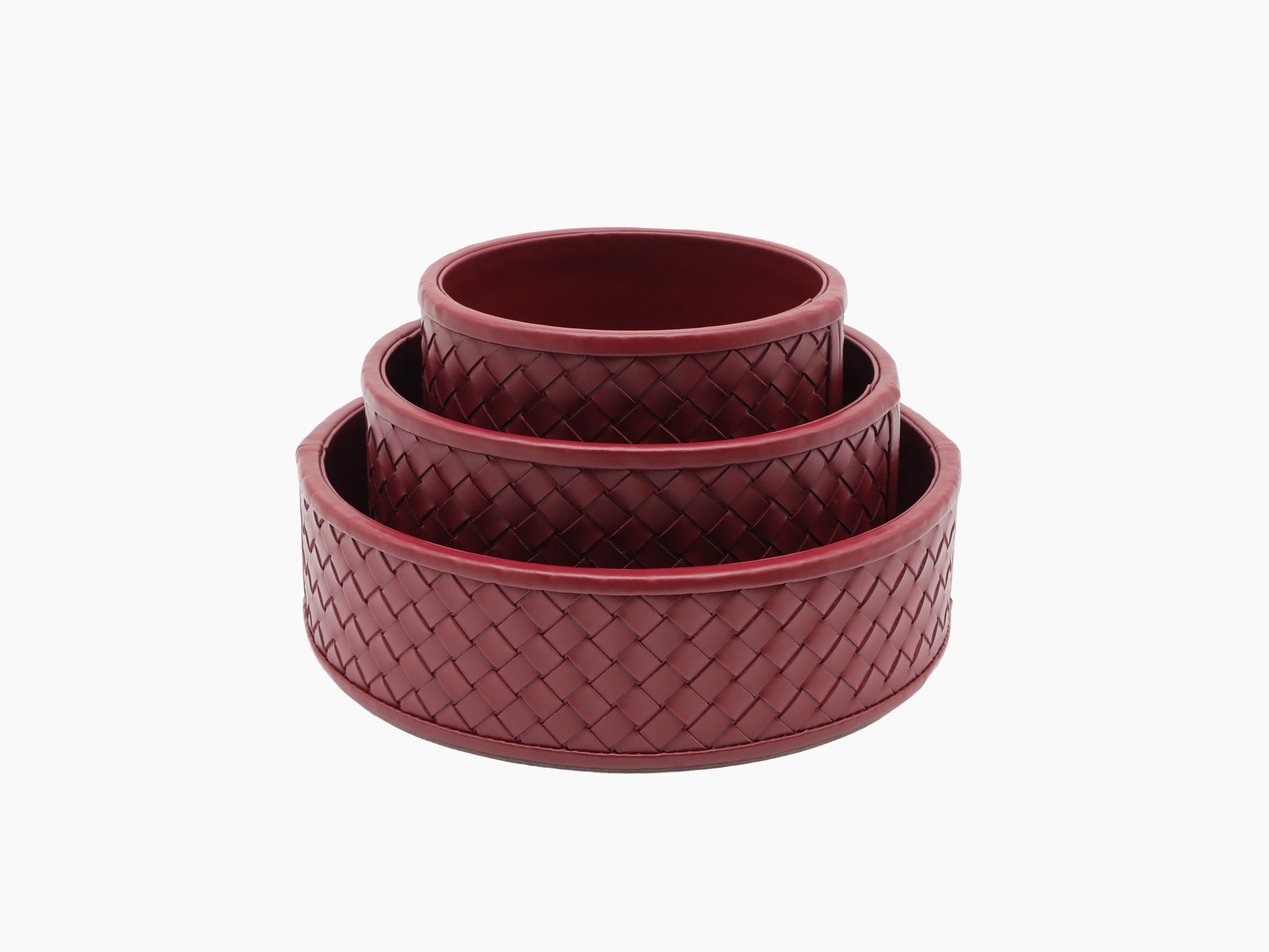 Stacked trio of burgundy Jana handwoven round leather boxes with quilted weave and looped lid handles