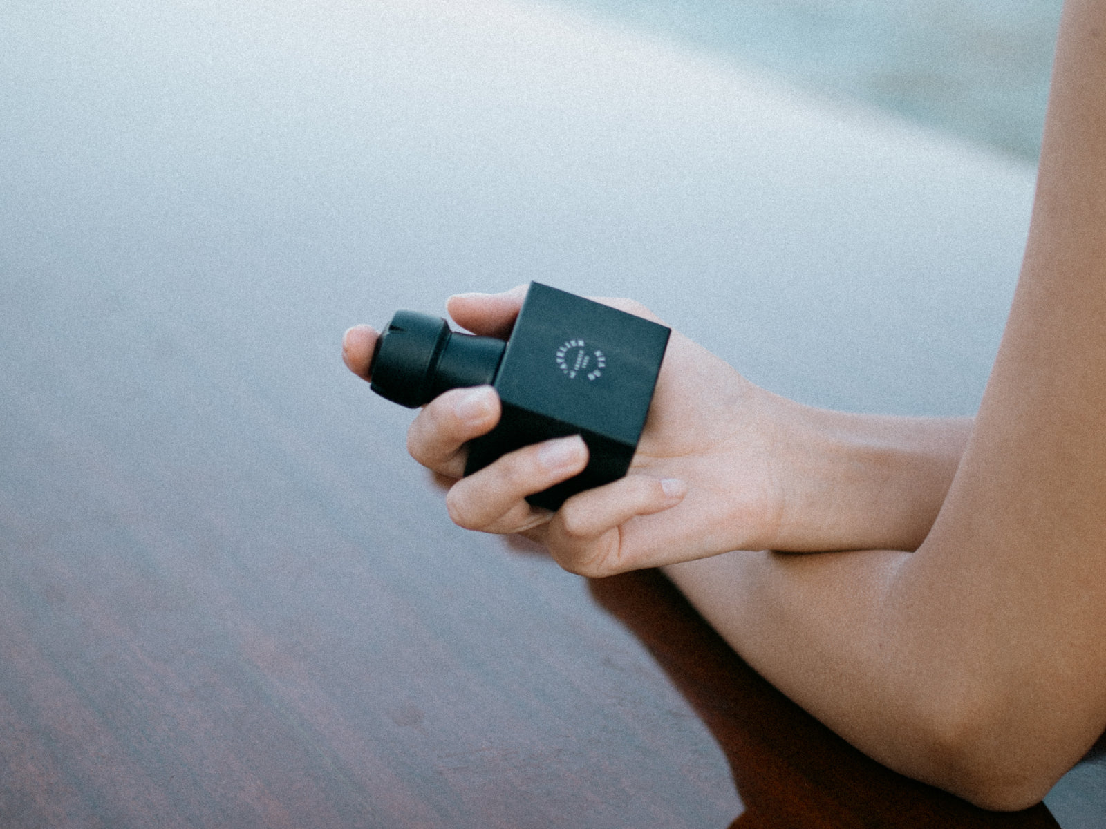 Hand holds Bubble Cork Black stopper with a square body and compact nozzle.