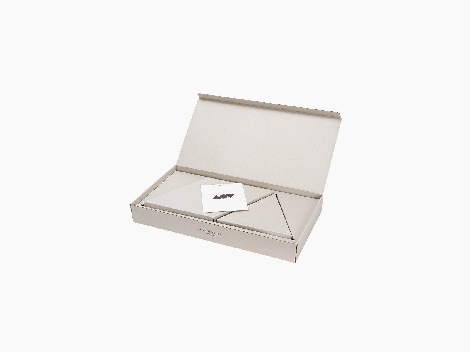 Open beige Geometry box with geometric interior panels and a small white card inside