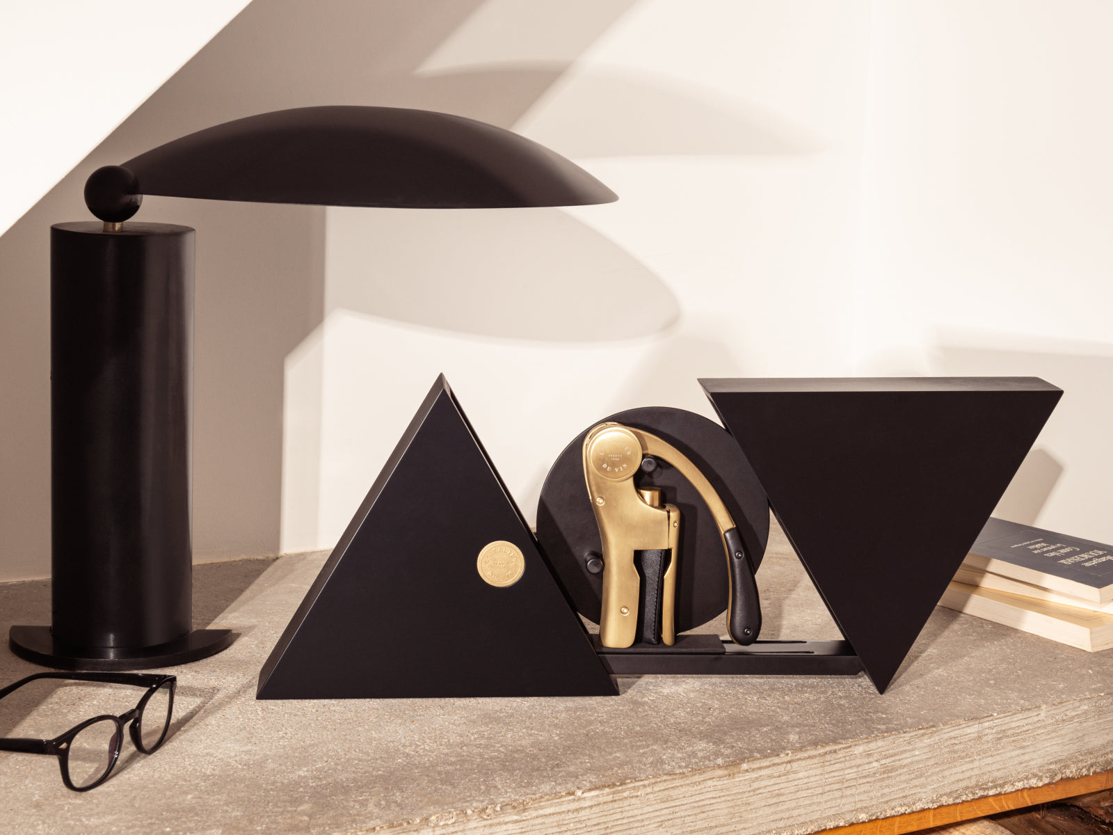 Geometry black lacquered wood box opens to reveal the gold Oeno Motion corkscrew inside a triangular geometric form