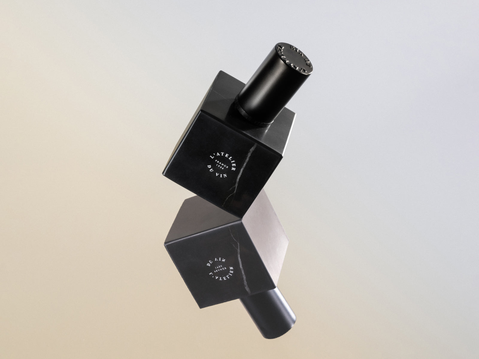 Le Bouchon Black wine stopper angled on stacked black marble blocks highlighting its alloy base and silicone seal.