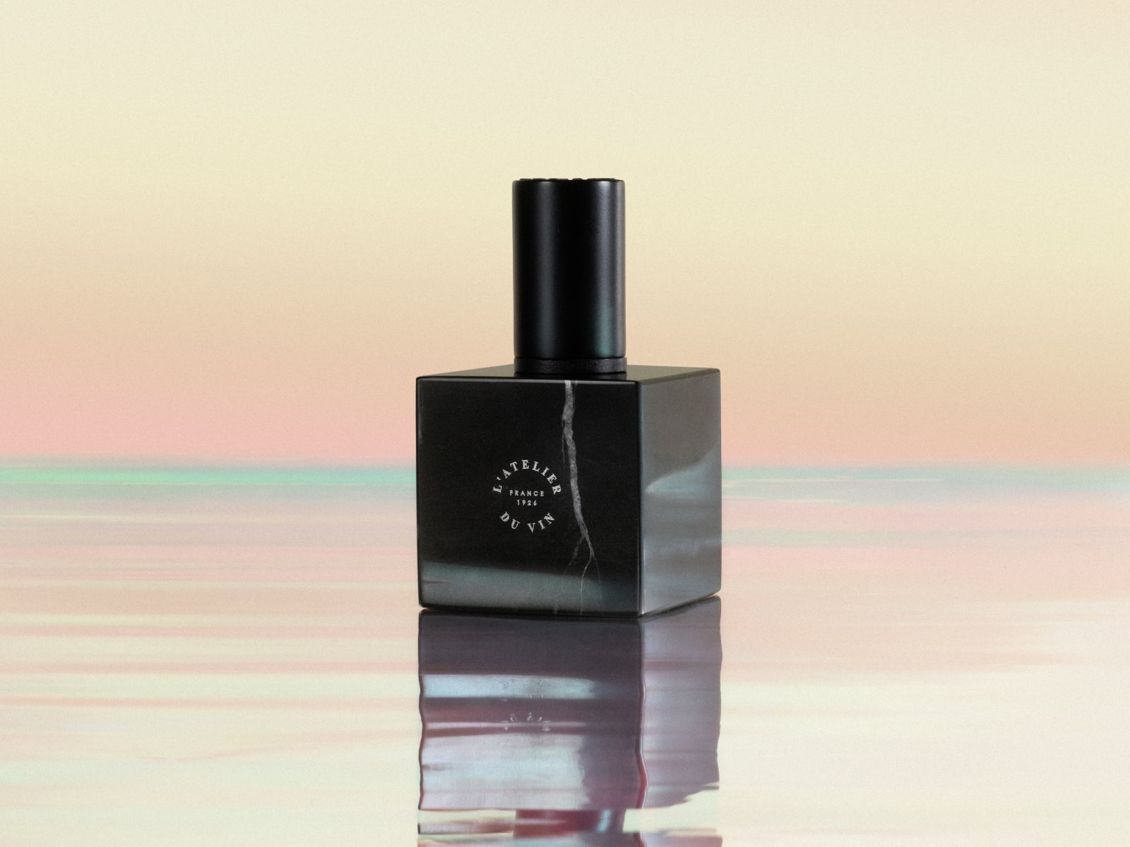 Le Bouchon Black wine stopper on a glossy black block with a white vein against a soft gradient backdrop.