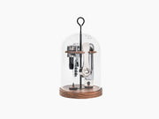 Le Globe glass dome wine tasting set resting on a walnut base with cork opener and other tools inside.