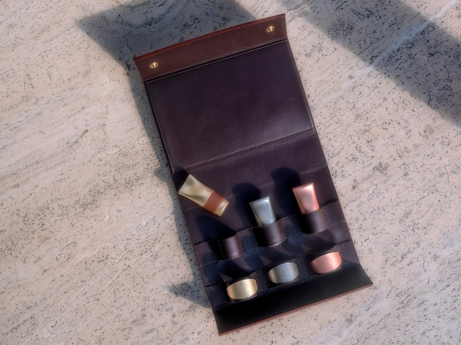 Purple leather case laid on stone with six wine tools tucked into individual slots