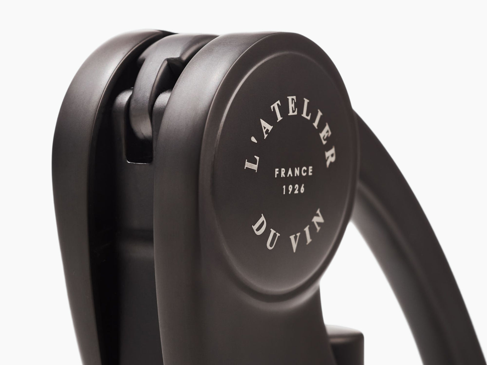 Close-up of the corkscrew mechanism showing L Atelier Du Vin branding on the wheel.