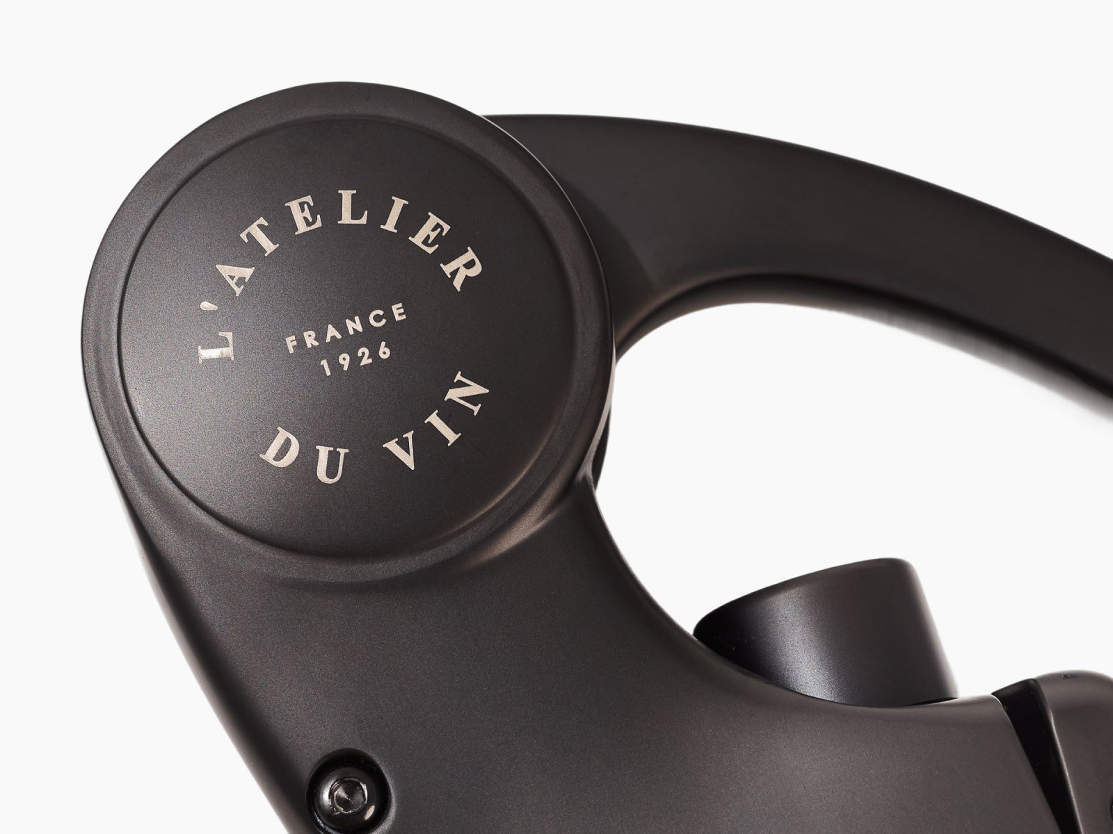 Circular cap with LATELIER DU VIN branding on the corkscrew head