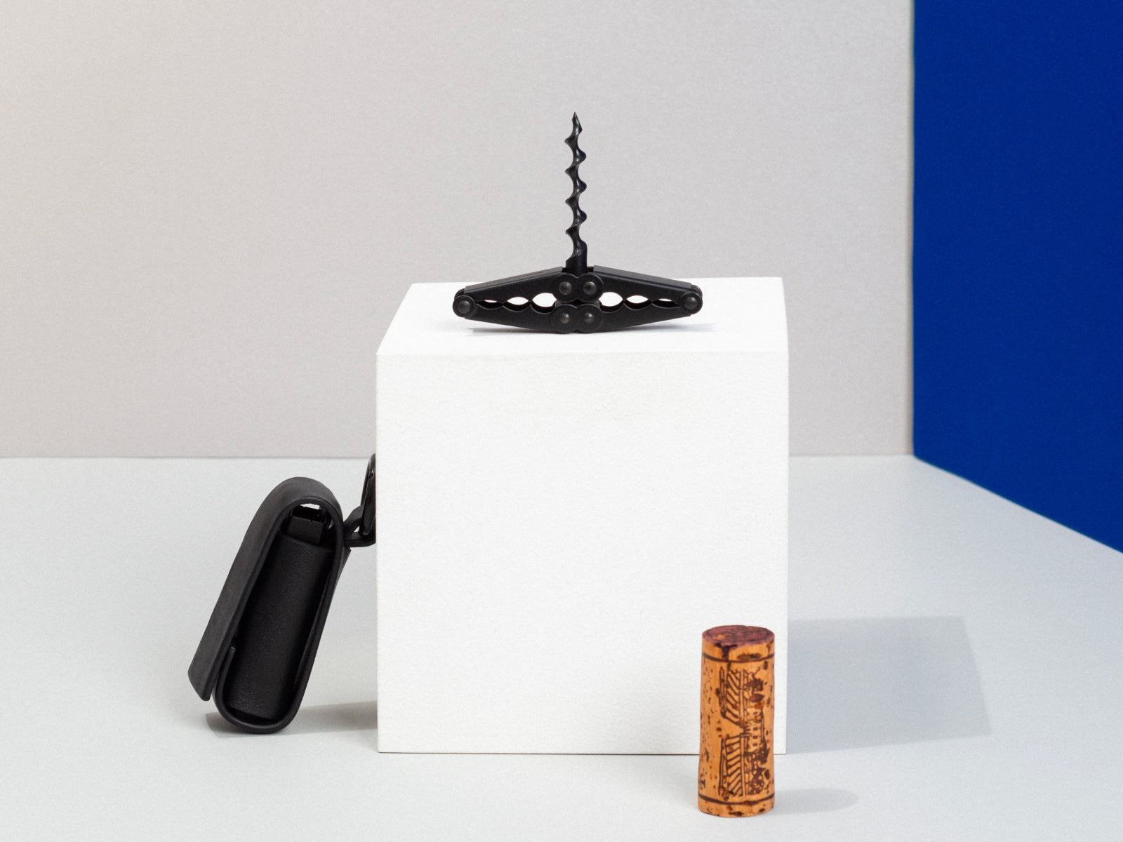 Pocket Collector black corkscrew displayed on a white block with a cork and a black sheath nearby.