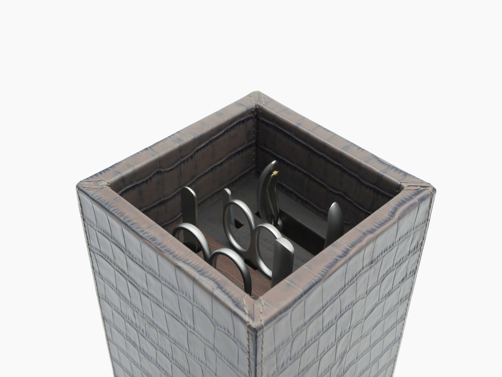 Open crocodile pattern leather manicure box with tools neatly arranged inside.