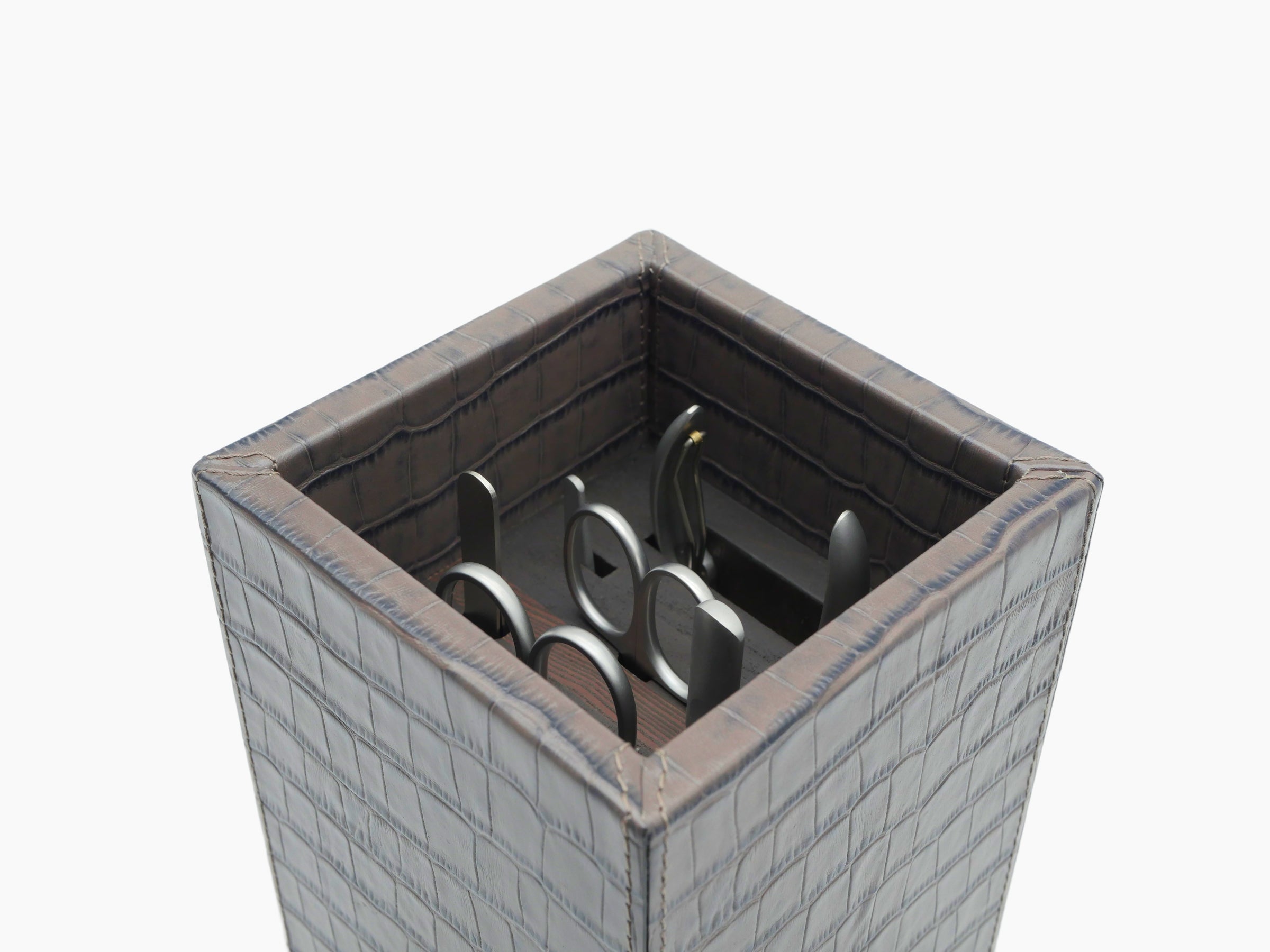 Open crocodile pattern leather manicure box with tools neatly arranged inside.