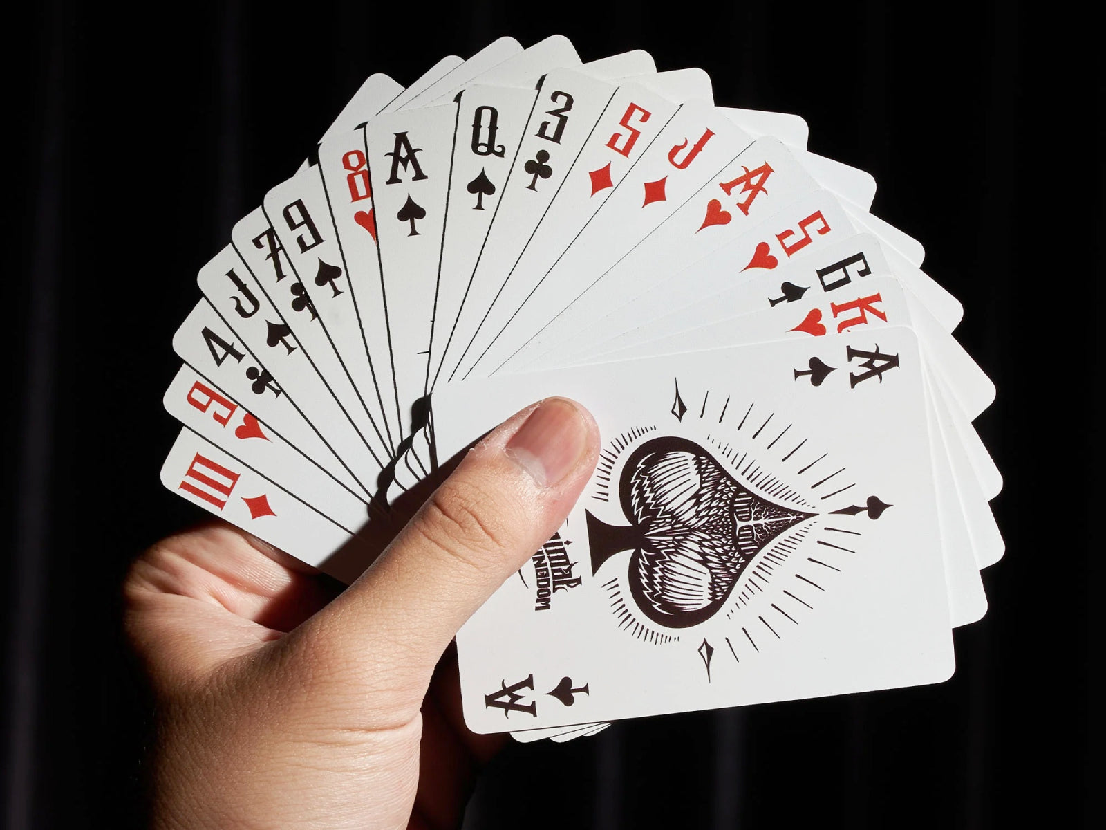 Fanned Animal Kingdom playing cards with woodcut style animal illustrations held in a hand