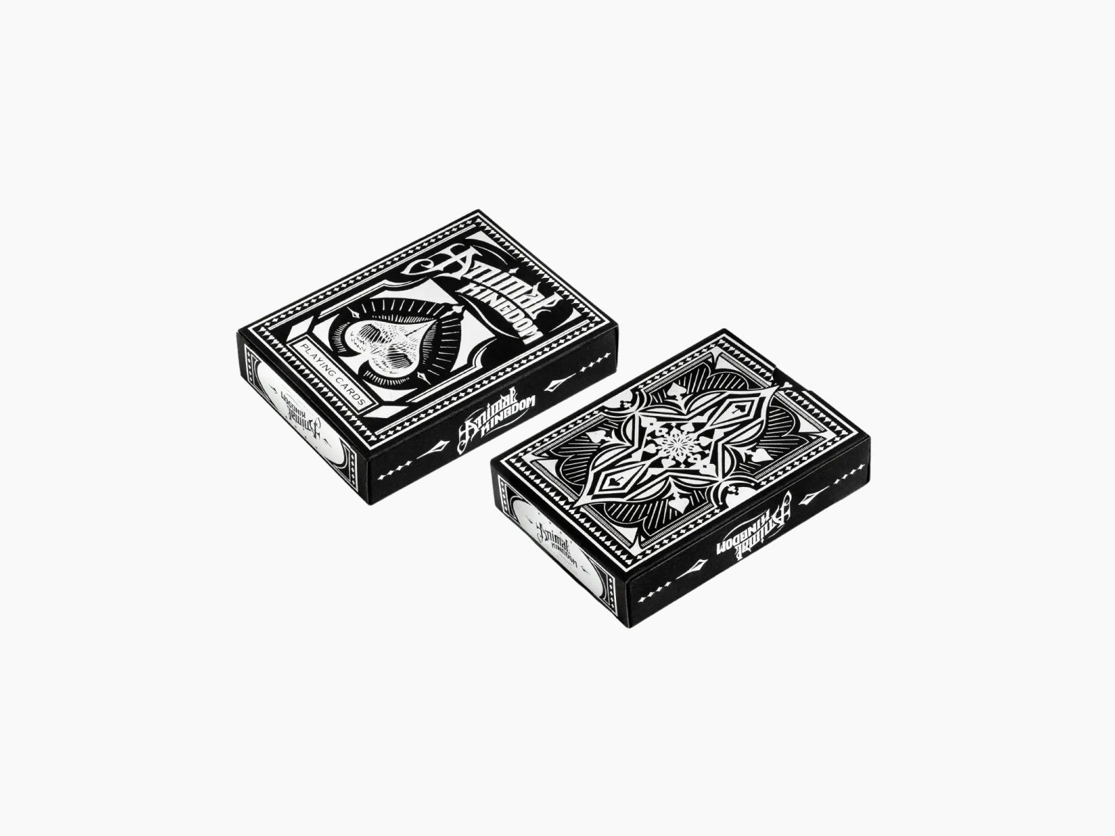 Two black and white ornate Animal Kingdom playing card boxes shown from an angled view