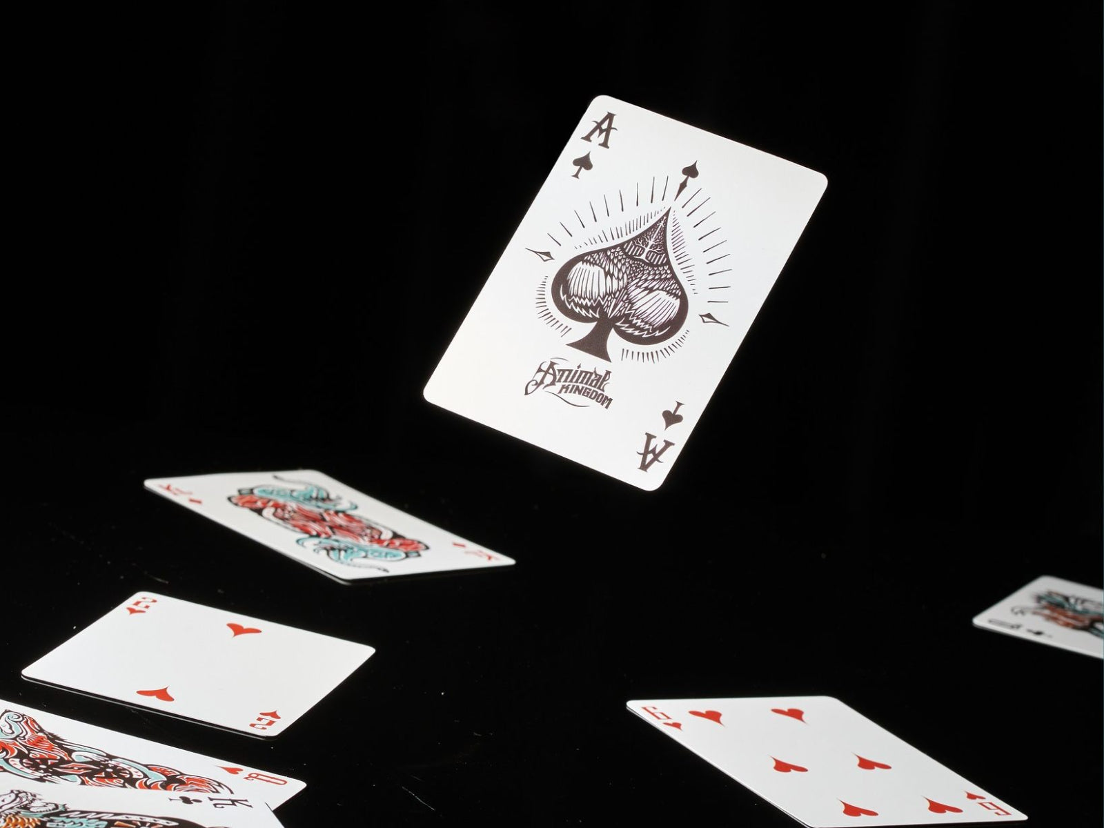 Floating Ace of Spades card from Animal Kingdom Playing Cards with ornate spade design against a dark backdrop.