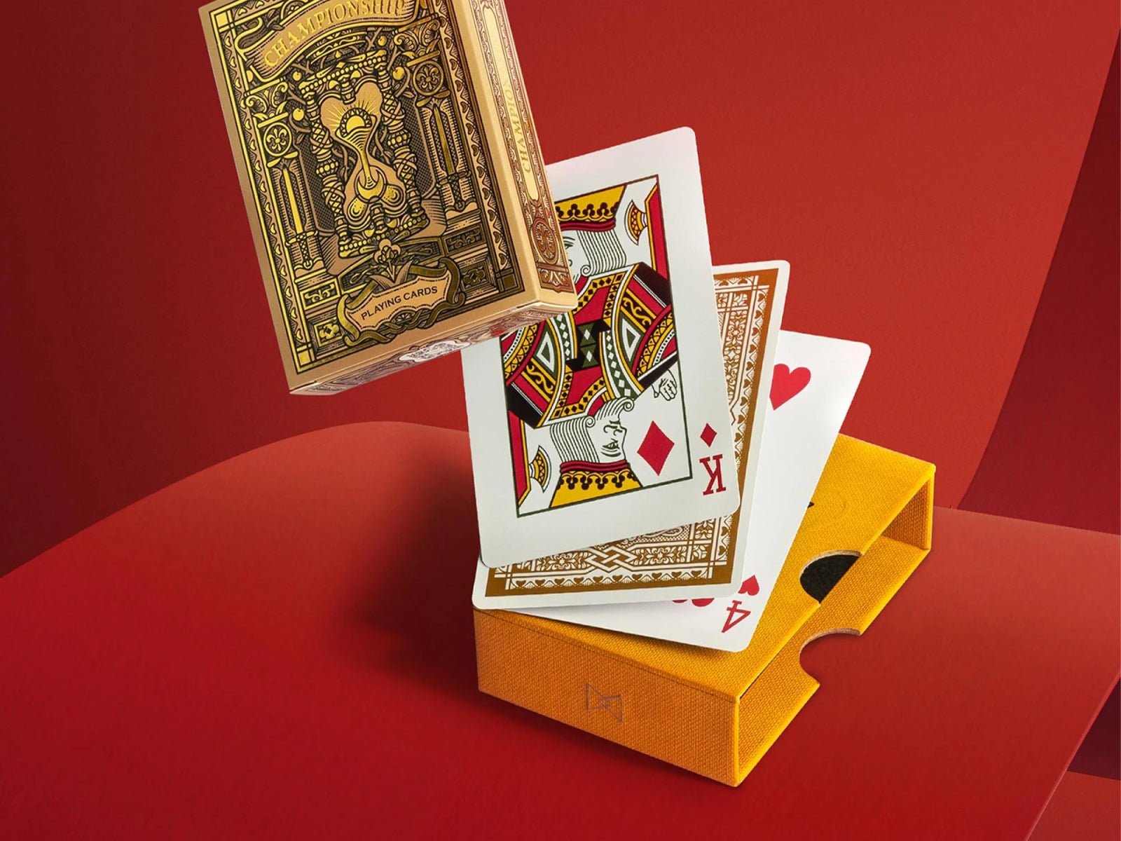Ornate gold Championship playing cards deck suspended above a red background beside a yellow box.