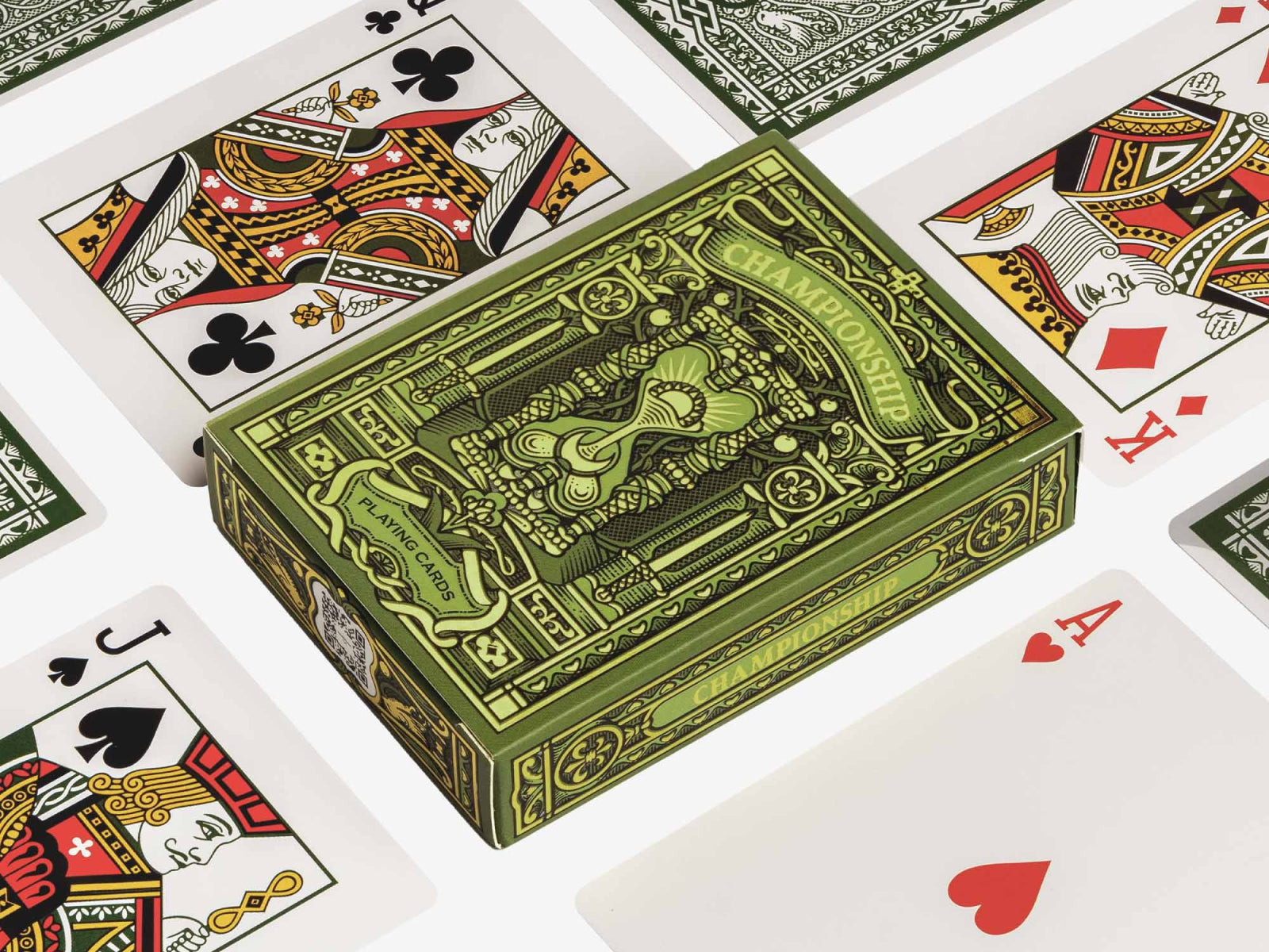 Green ornate Championship playing cards box with decorative engravings beside a black display sleeve