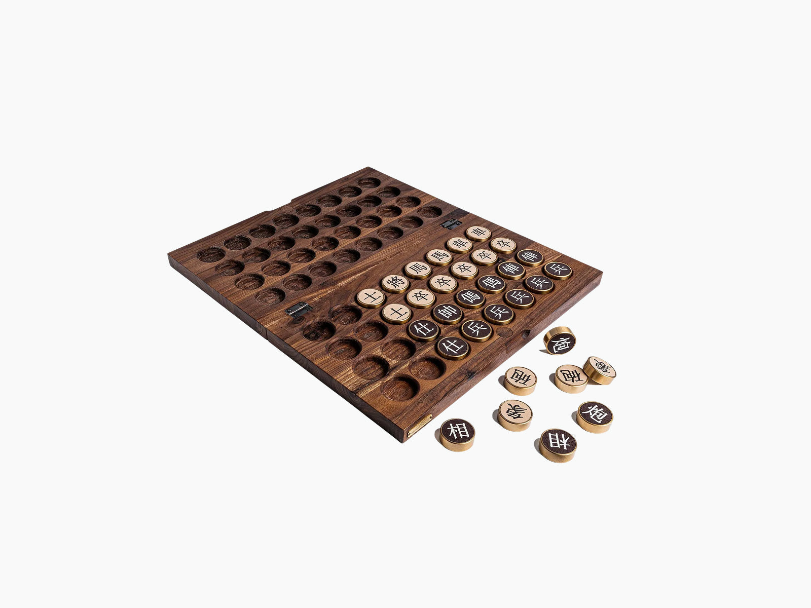 Walnut compact Chinese chess board with recessed pits and bronze and light wood game pieces arranged beside it.