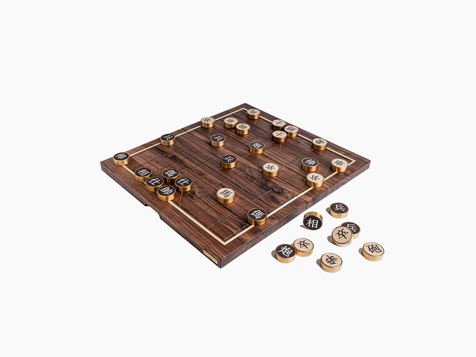 Angled view of a walnut compact Chinese chess board with bronze pieces in play and spare discs nearby
