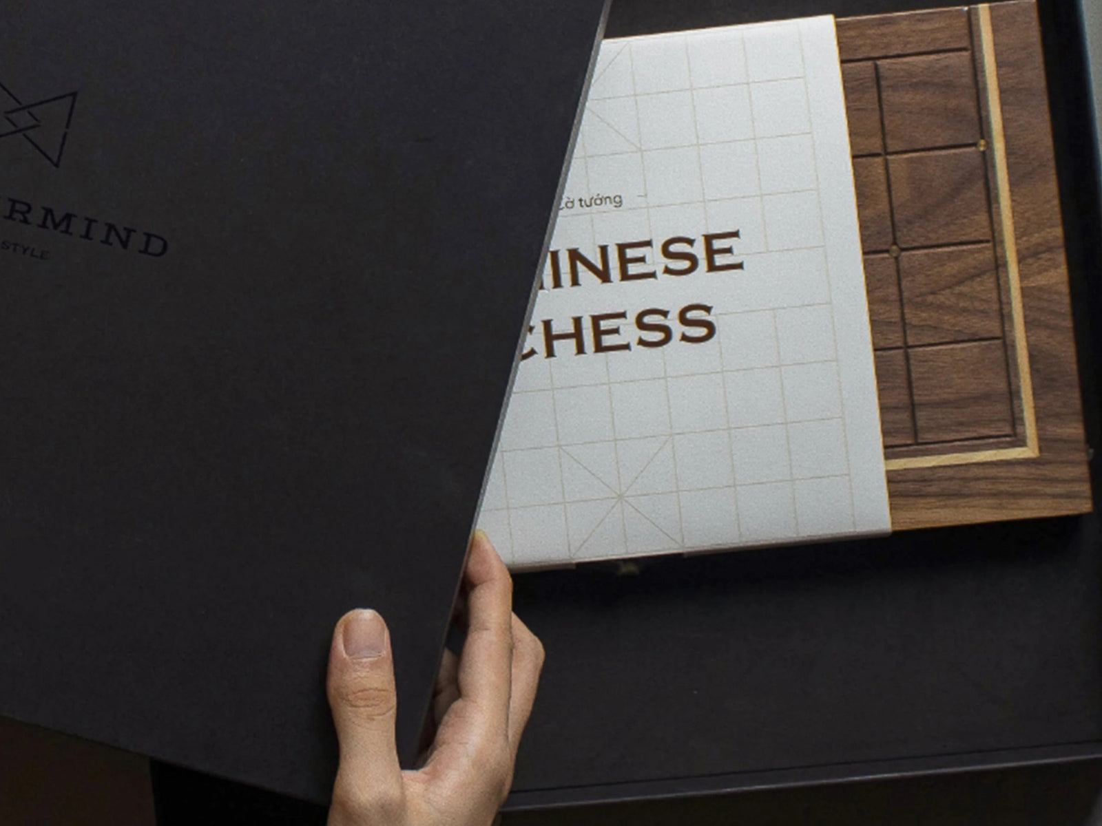 Opened Maztermind box reveals a wooden Chinese chess board and booklet labeled Chinese Chess