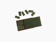 Open walnut box with green leather domino tiles scattered around it