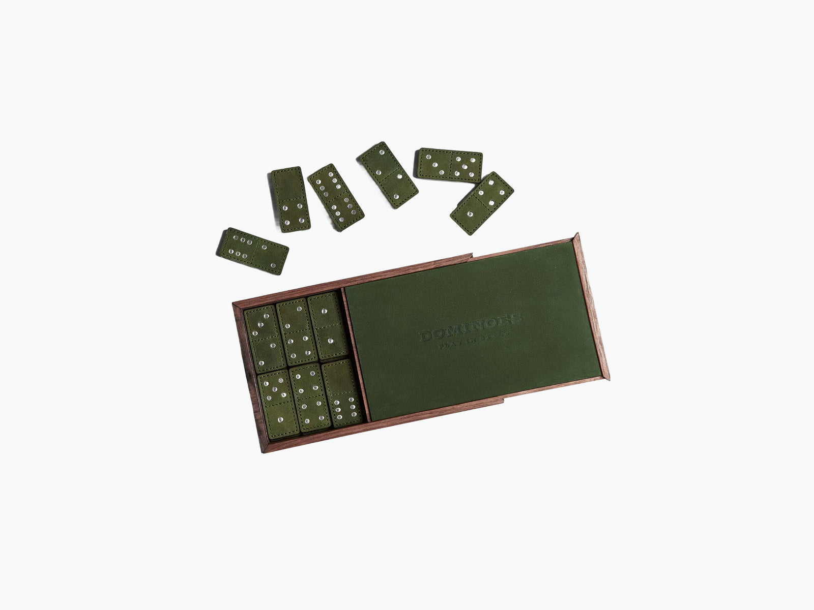 Open walnut box with green leather domino tiles scattered around it