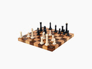 Nomad portable chess set on a walnut and beech modular board with white and black pieces ready to play.