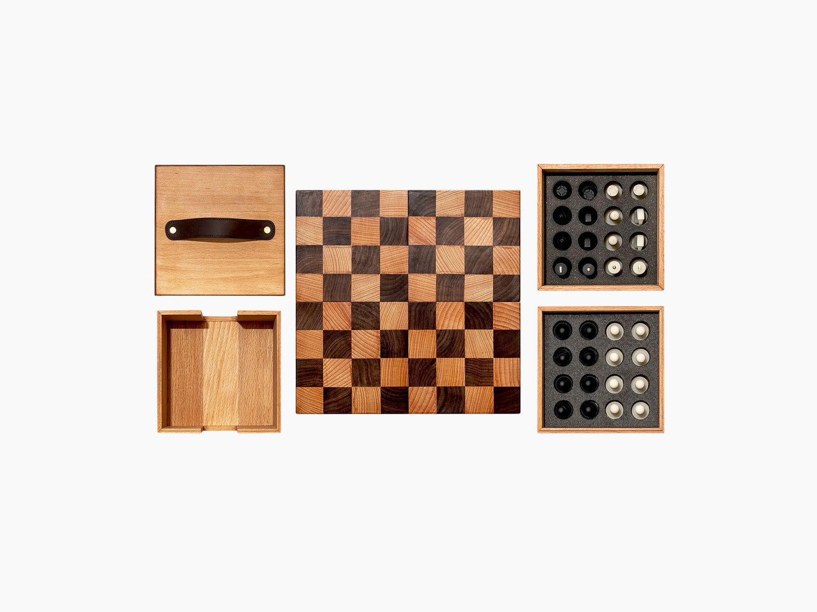 Nomad portable chess set arranged with board in center foam trays of pieces on the right and wooden lid on left