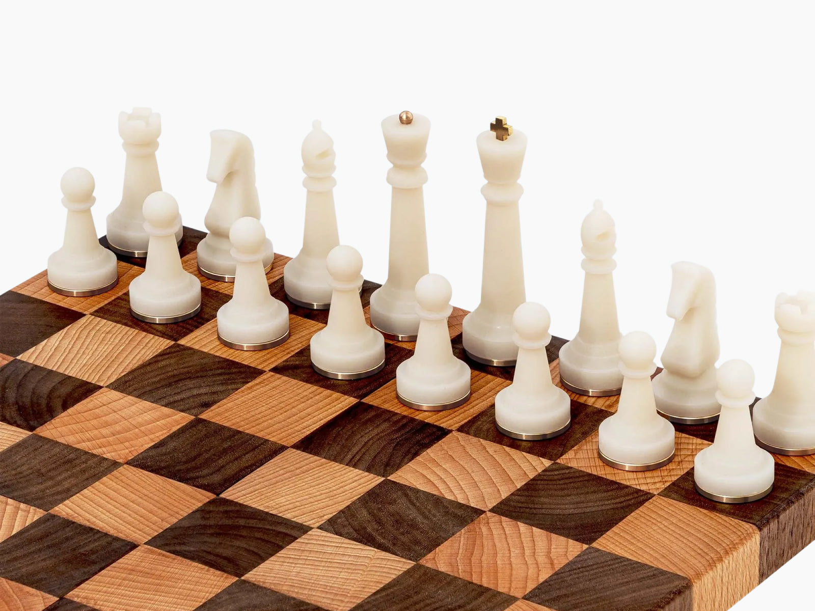 Cream white Nomad chess pieces displayed in a two-tier wooden box beside a light dark wood checkered board