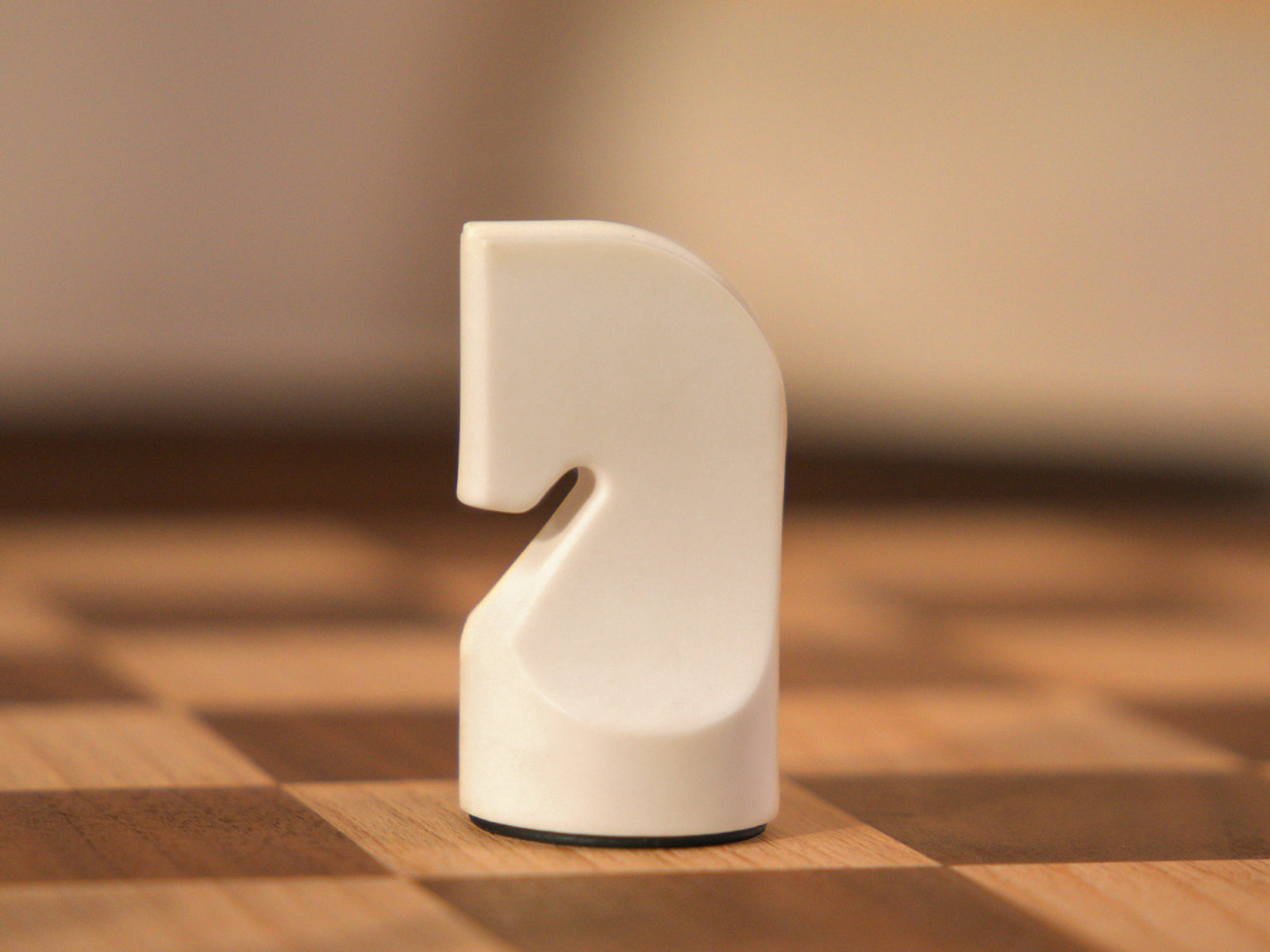 Close-up of a white sculpted chess piece from The Regal Chess Set on a checkered wooden board.