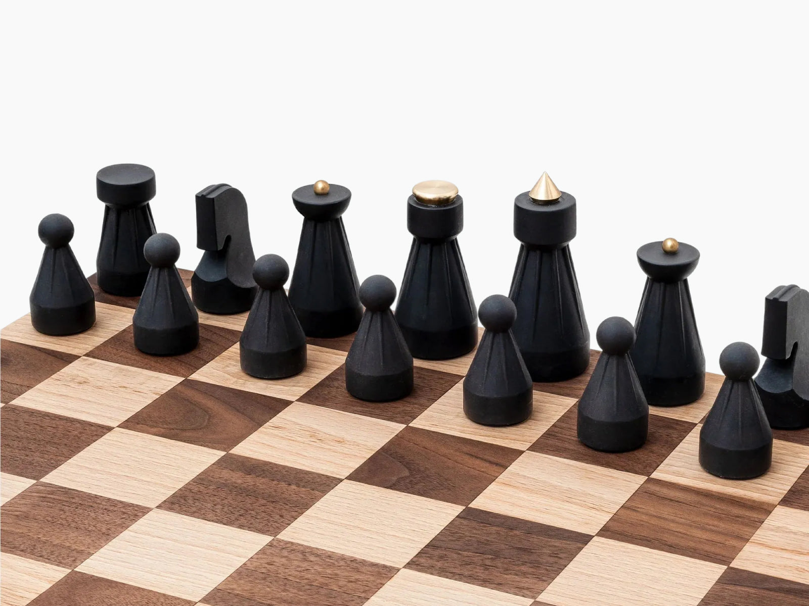 Black and white The Regal Chess Set pieces arranged on a wooden chessboard.