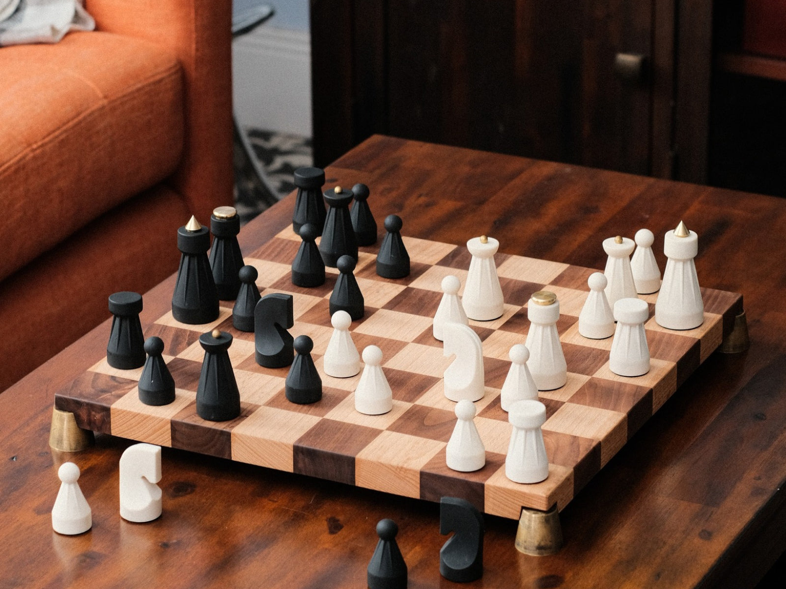 Full chessboard setup of The Regal Chess Set with black and white pieces on a wooden table.