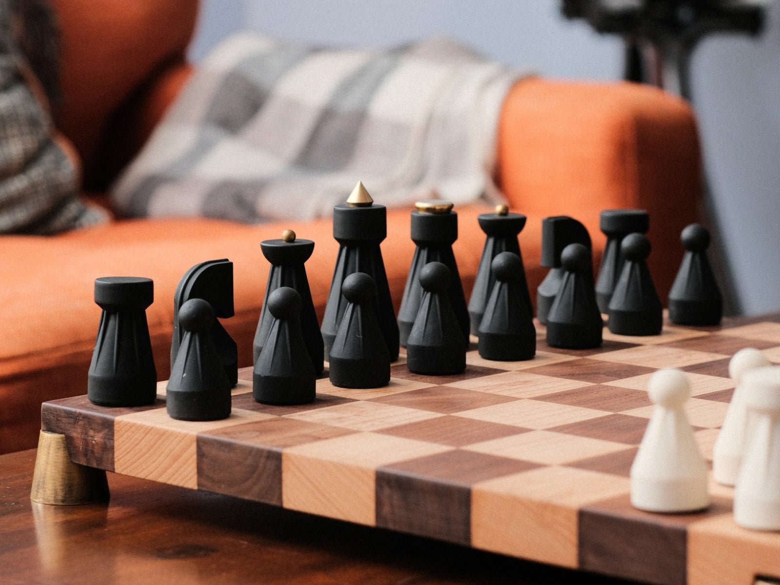 Close-up of black and white Regal chess pieces on a wooden chessboard seen from a low angle