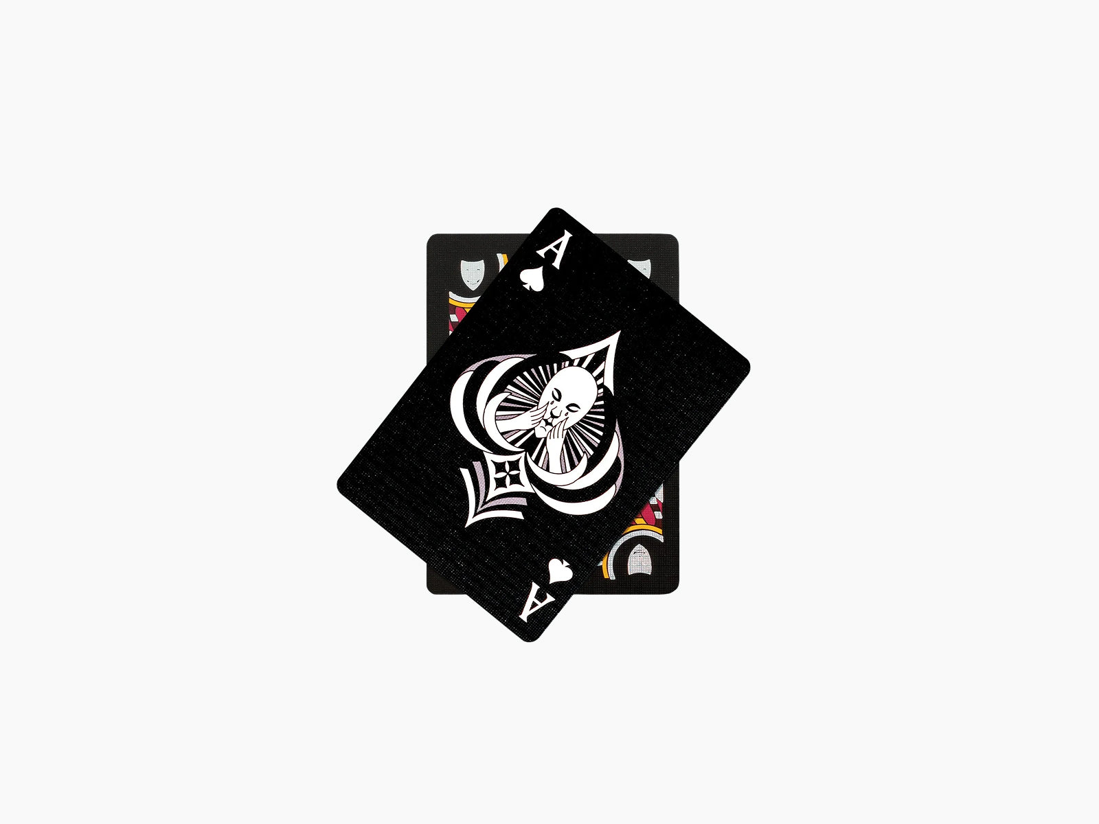 Ritual Masks playing cards deck with black backs stacked; top card features a white stylized mask with circular accents.