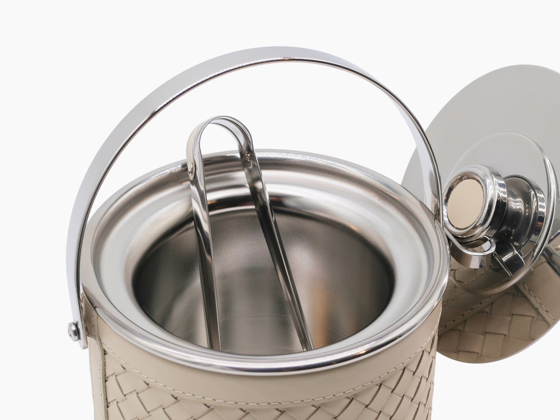 Menfi ice bucket with polished stainless interior, beige handwoven leather exterior, and matching tongs.