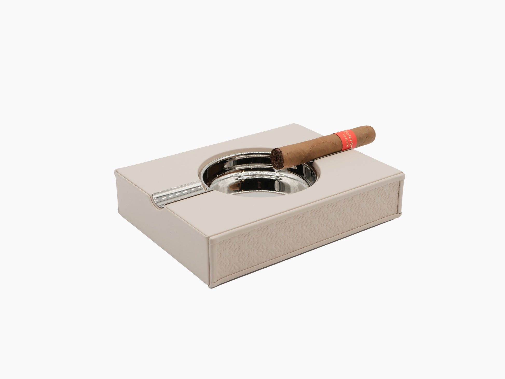 Beige Monogram Table Ashtray with embossed pattern and palladium trim atop a matching beige box