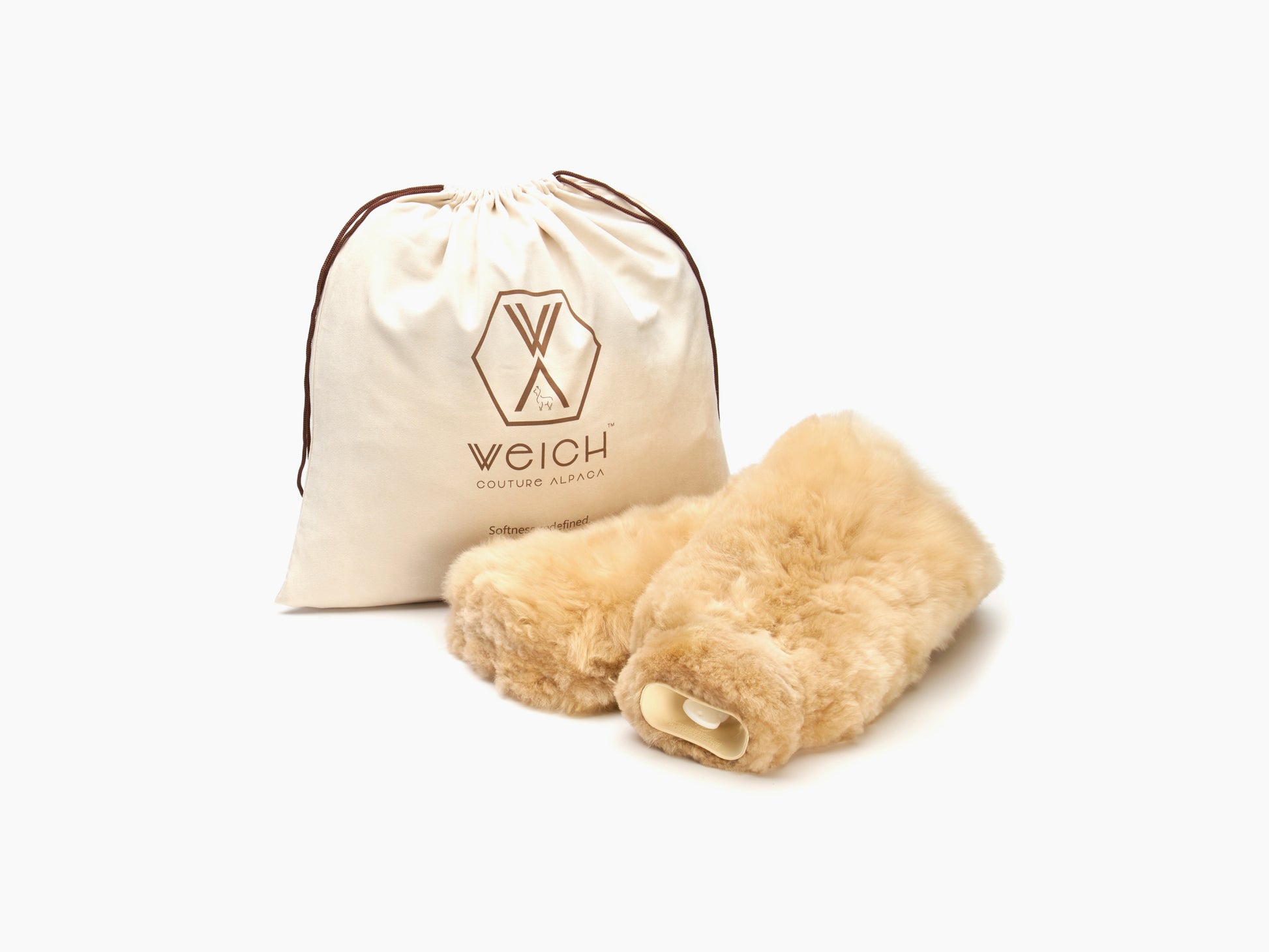 Beige plush fur neck hot water bottle placed in front of a cream drawstring bag with a logo