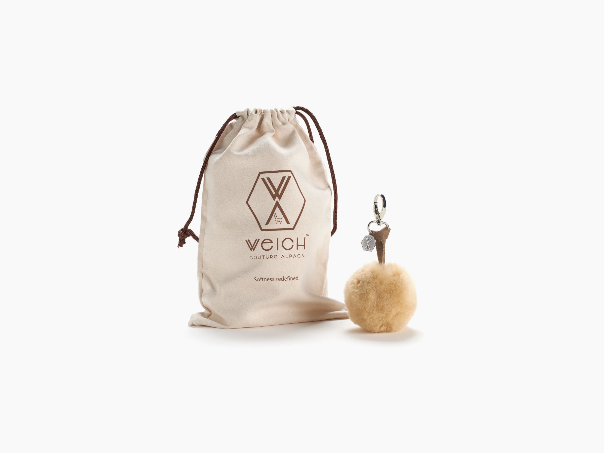 Beige Pompom CLAVE drawstring pouch with brown logo and fluffy keychain.