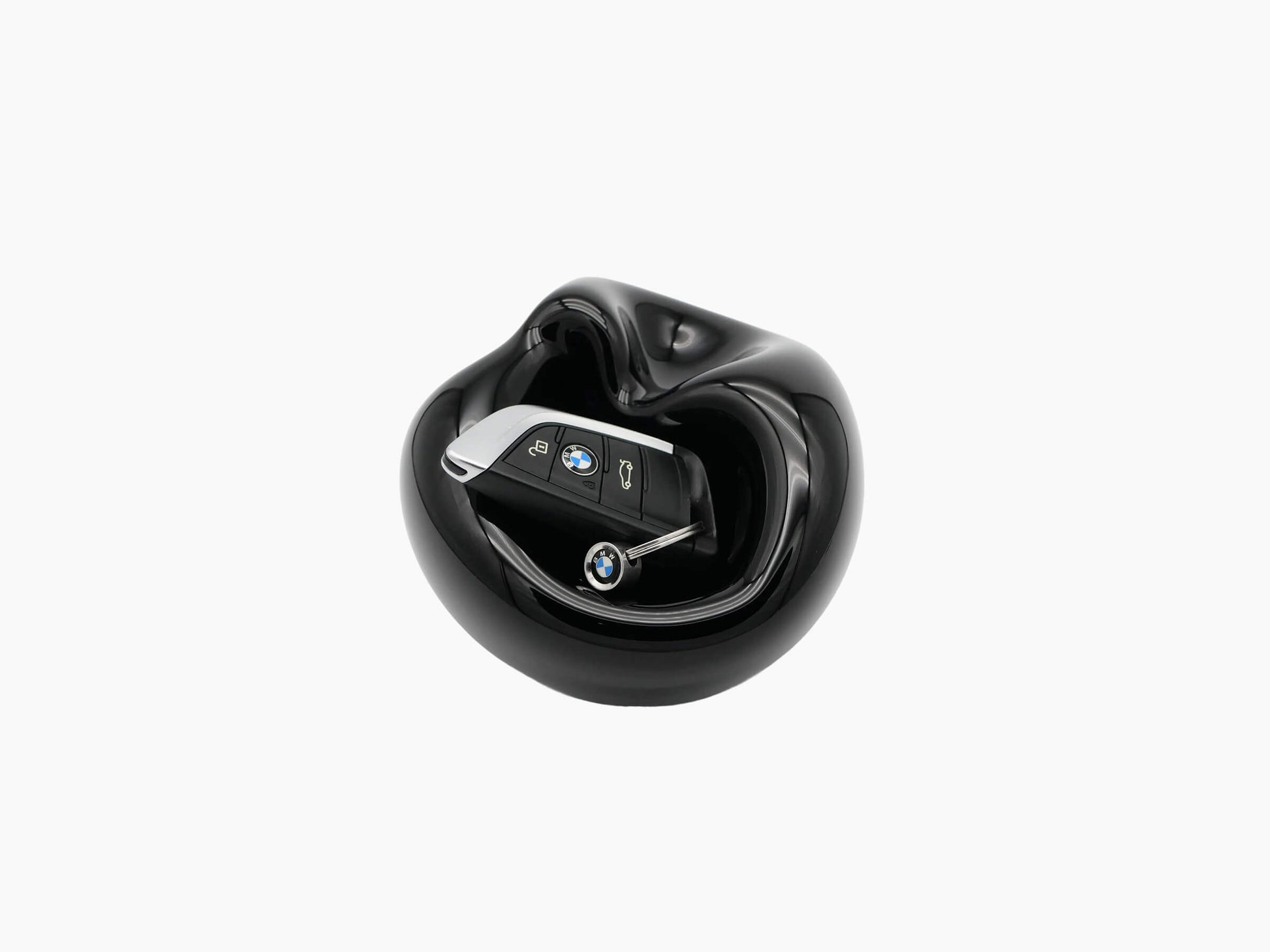 Large Obsidian Black Vessel hand blown glass with a curved bulbous form and a BMW key fob resting inside