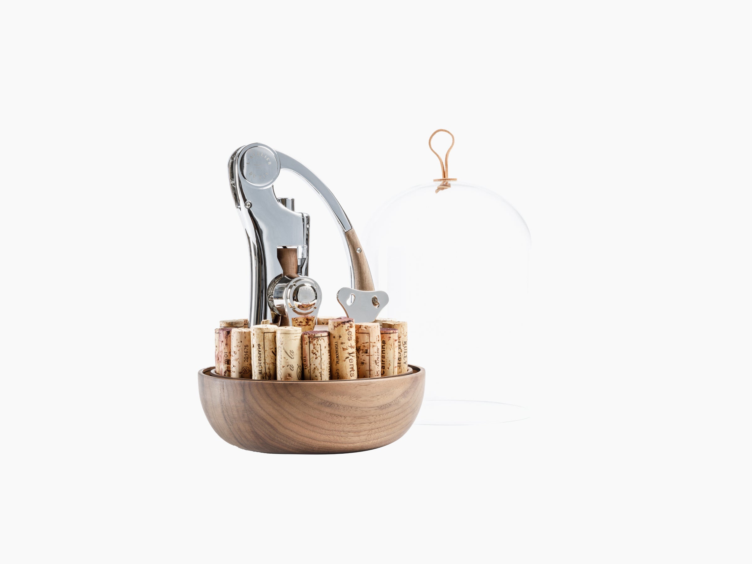 Oeno Motion Groom set with stainless steel corkscrew in a walnut bowl surrounded by corks and a glass dome