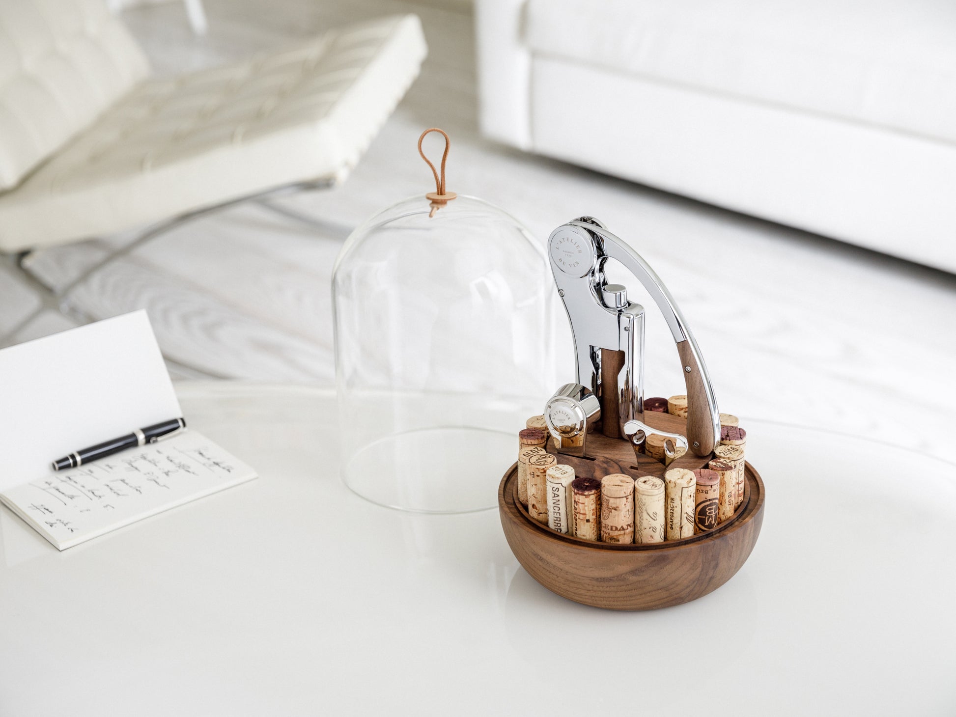 Oeno Motion Groom wine service set under a hand blown glass dome on a walnut base with corks arranged around.
