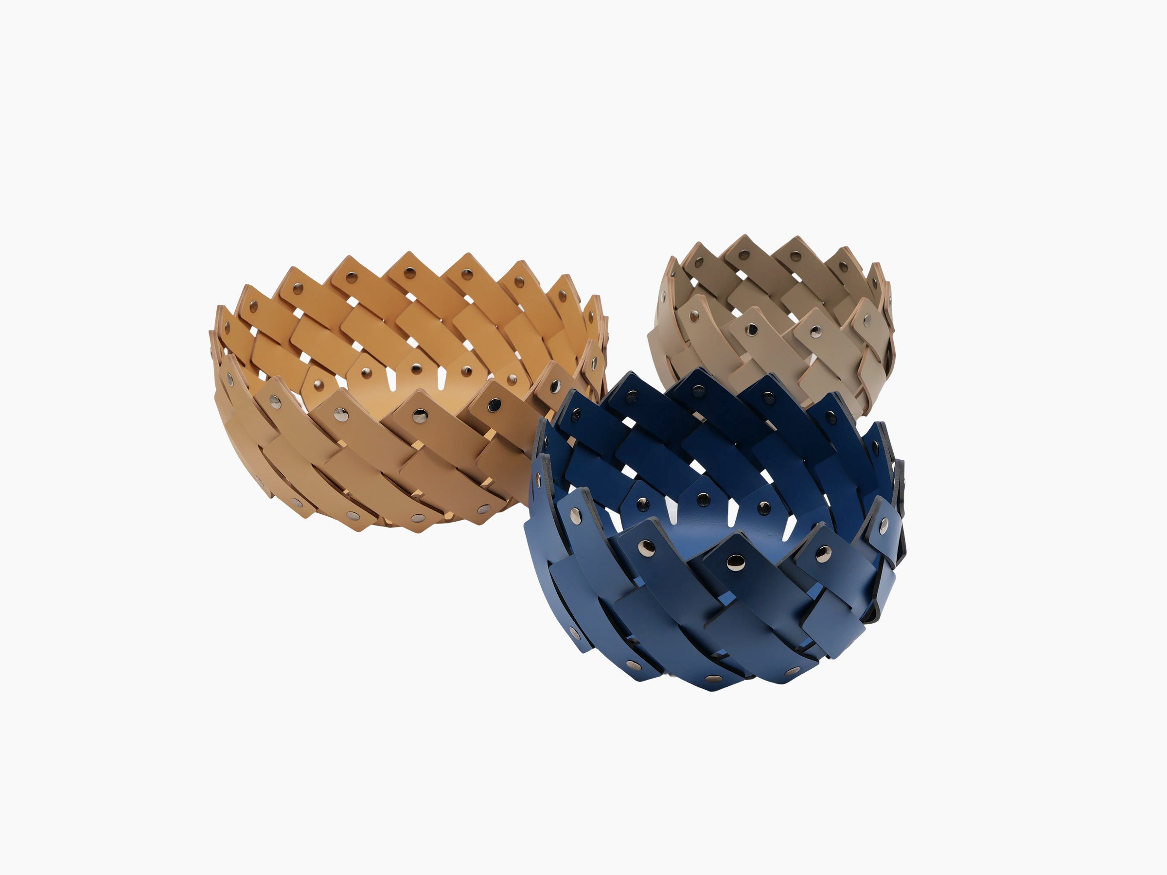 Three Almeria Round Emptypockets towel baskets in tan blue and gray arranged in a sculptural cluster