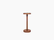 Champagne bucket set on a tall brown stand with a circular base